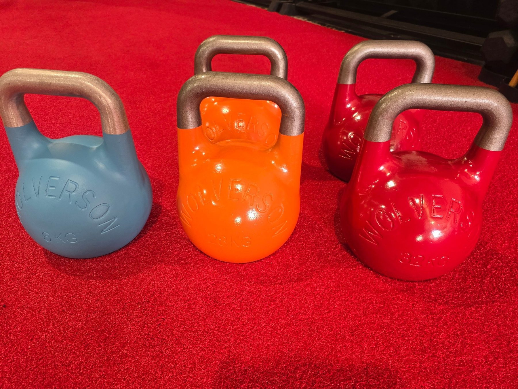 Wolverson competition kettlebells lined up on the red gym floor