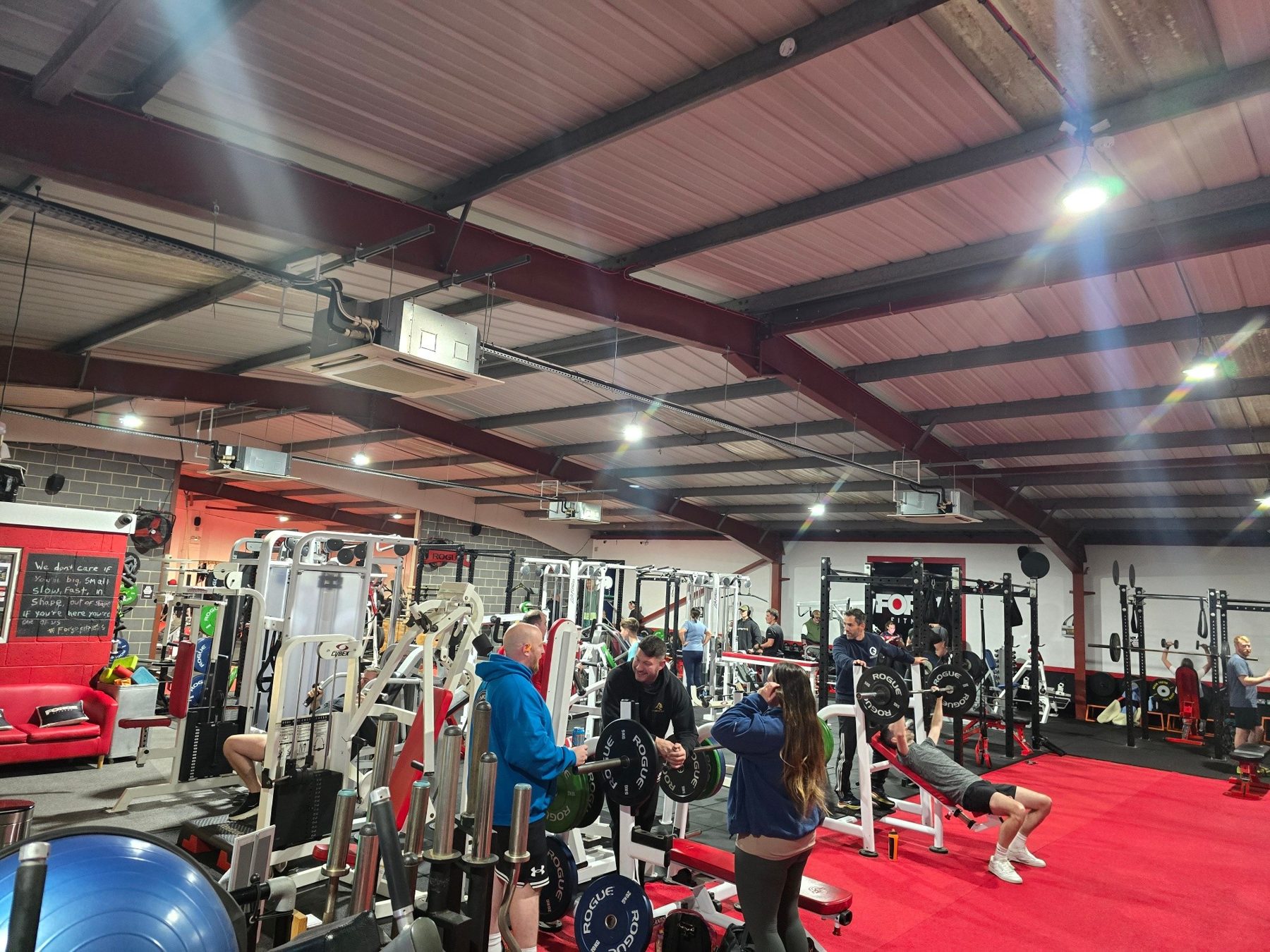 Members training between rows of machines on Forge's red floor